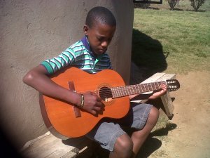 Menzi with Guitar given by someone at Coming King Ministries